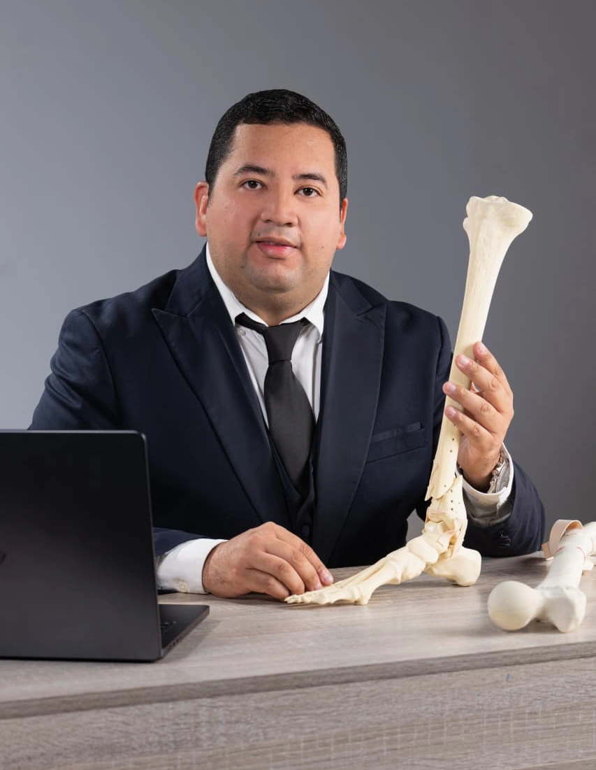 Dr. Erick Ponce en consulta ortopédica con modelo anatómico en San Pedro Sula y alrededores